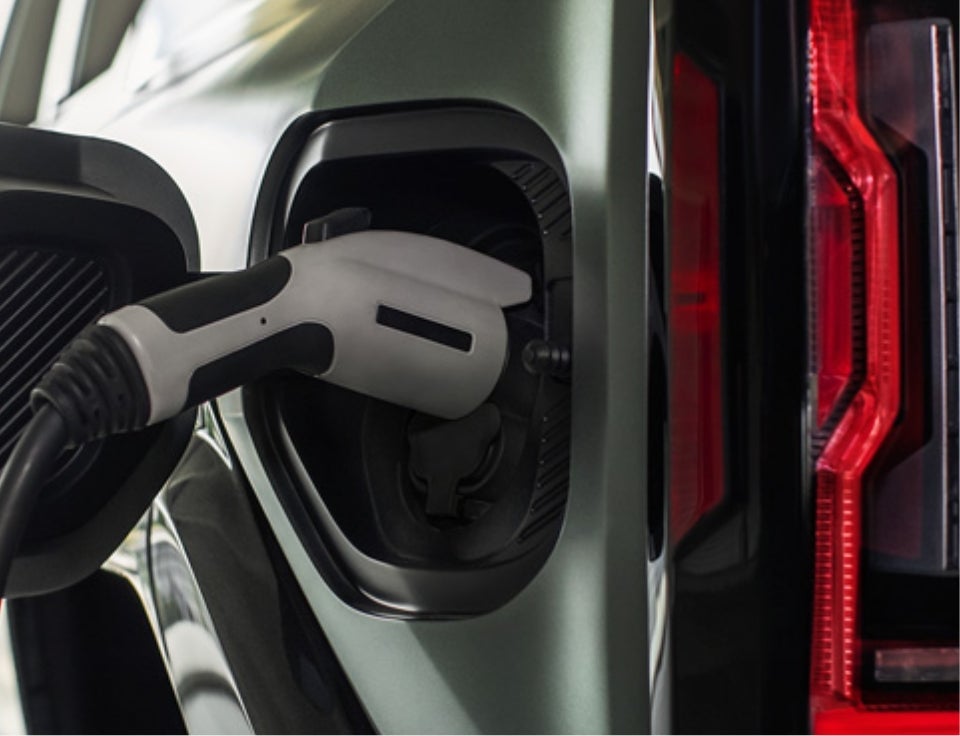 Close up of charging port with charger plugged in on a GMC Hummer EV SUV - Roe Motors in Grants Pass OR